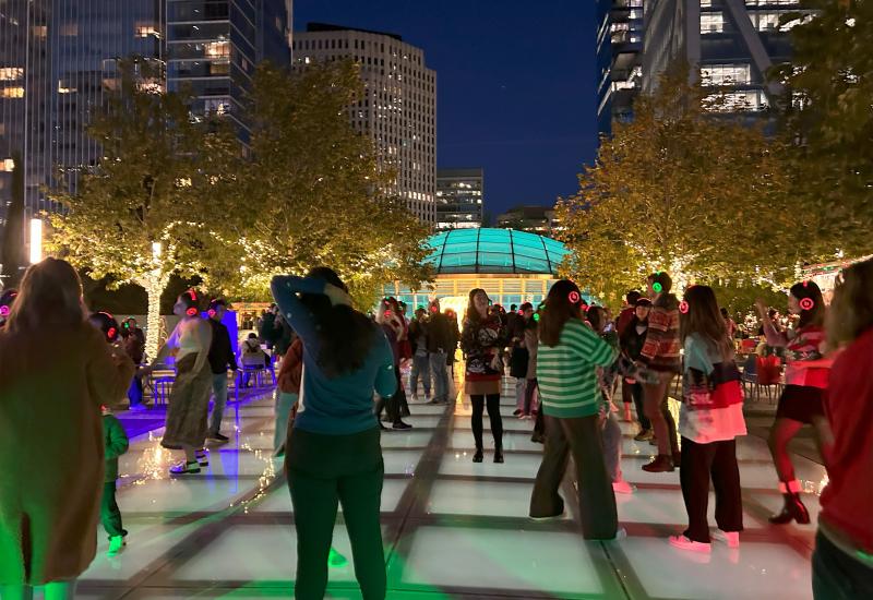 Group of people dancing at night in TJPA's Salesforce Park on the Main Plaza.